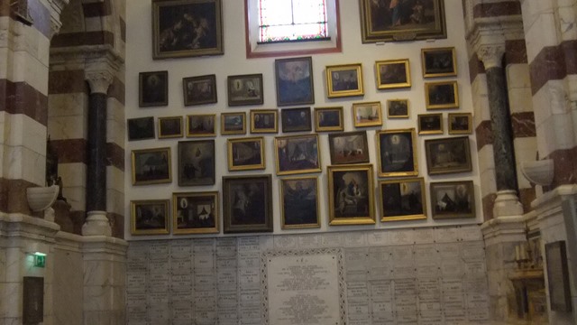 Peretii bazilicii Notre Dame de la Garde ereau plini cu tablouri ale unor copii si oameni normali probabil puse acolo de familii dupa pierderea lor